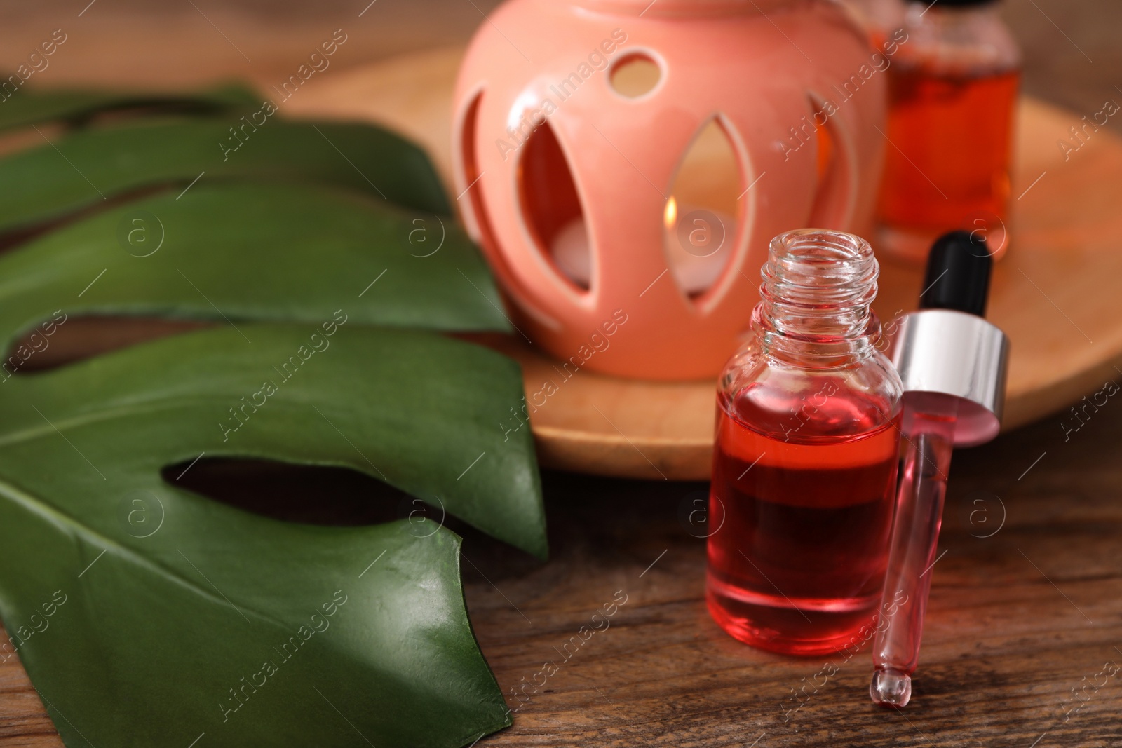 Photo of Bottle of essential oil for aroma lamp on wooden table