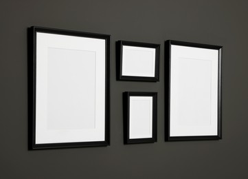 Photo of Empty frames on black wall. Mockup for design