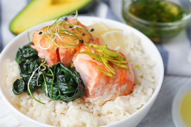 Photo of Tasty salmon with rice and spinach on white wooden table, closeup