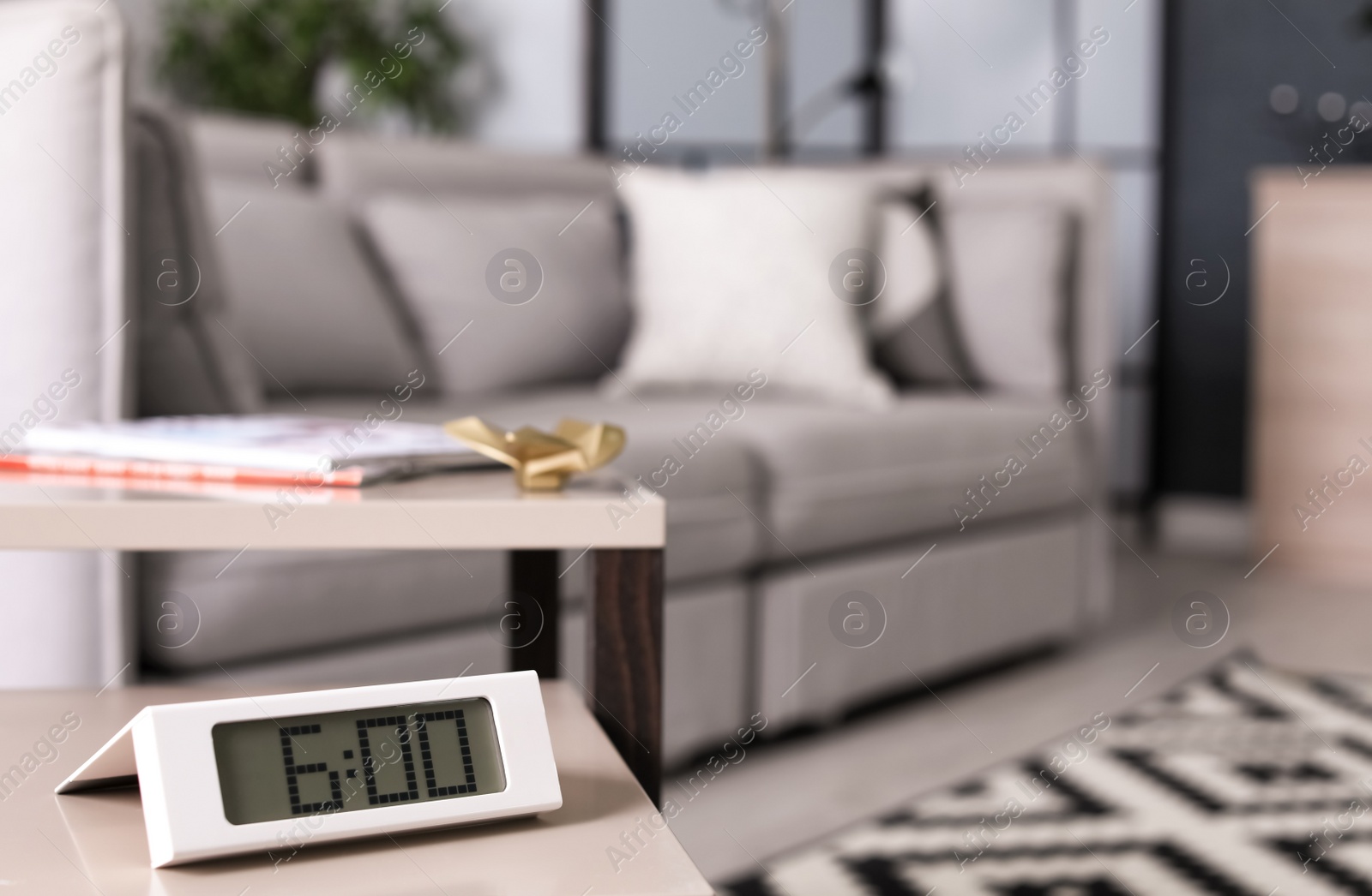 Photo of Digital alarm clock on table in living room. Time of day