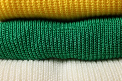 Stack of casual warm sweaters as background, closeup view