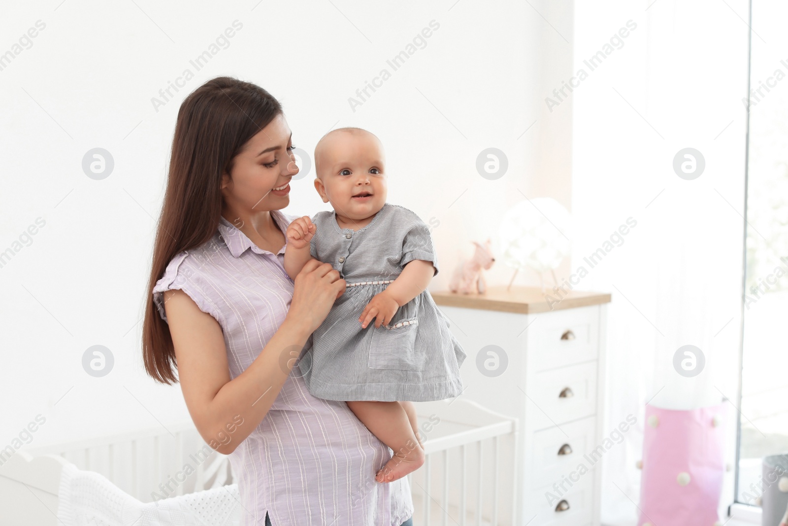 Photo of Young mother with her cute baby girl at home