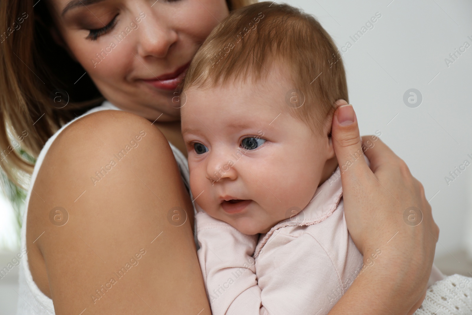 Photo of Young woman with her little baby resting after breast feeding at home, closeup