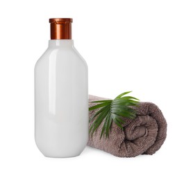 Bottle of shampoo and terry towel on white background