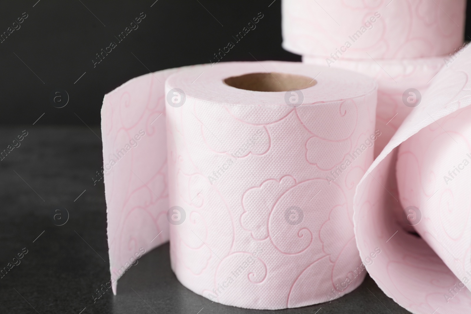 Photo of Soft toilet paper rolls on black background