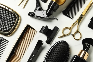 Hairdressing tools on white table, flat lay