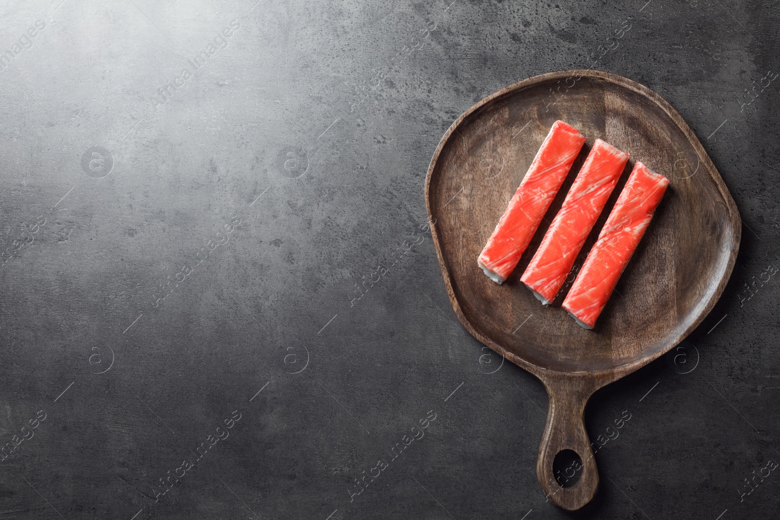 Photo of Crab sticks on grey table, top view. Space for text