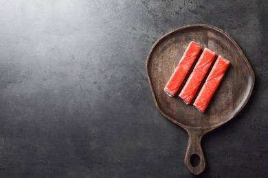 Photo of Crab sticks on grey table, top view. Space for text