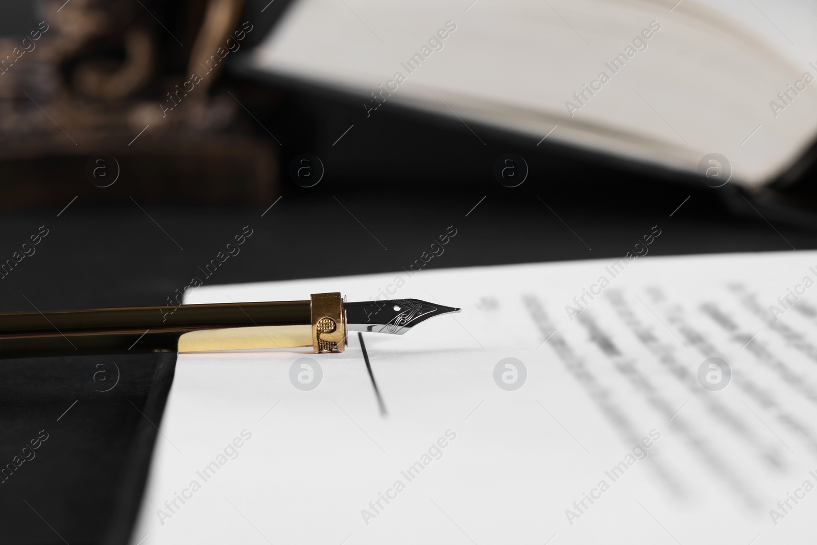 Photo of Fountain pen and paper document on dark table, closeup with space for text. Notary service