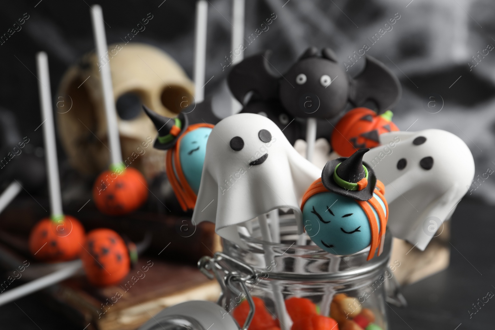 Photo of Different Halloween themed cake pops on dark background, closeup