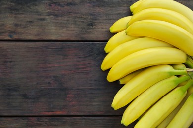 Photo of Ripe yellow bananas on wooden table, flat lay. Space for text