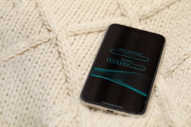 Photo of Smartphone with blocked screen on white knitted plaid, space for text
