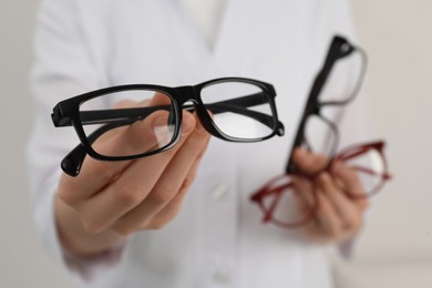 Photo of Woman with different glasses on light background, closeup