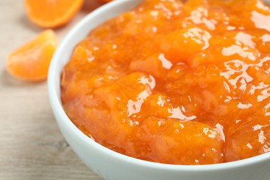 Delicious tangerine jam in bowl on table, closeup