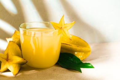 Photo of Delicious carambola juice in glass on light table