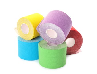 Photo of Many bright kinesio tape in rolls on white background