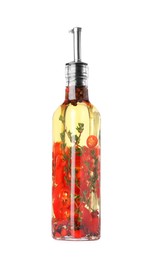 Photo of Glass bottle of cooking oil with spices and herbs isolated on white