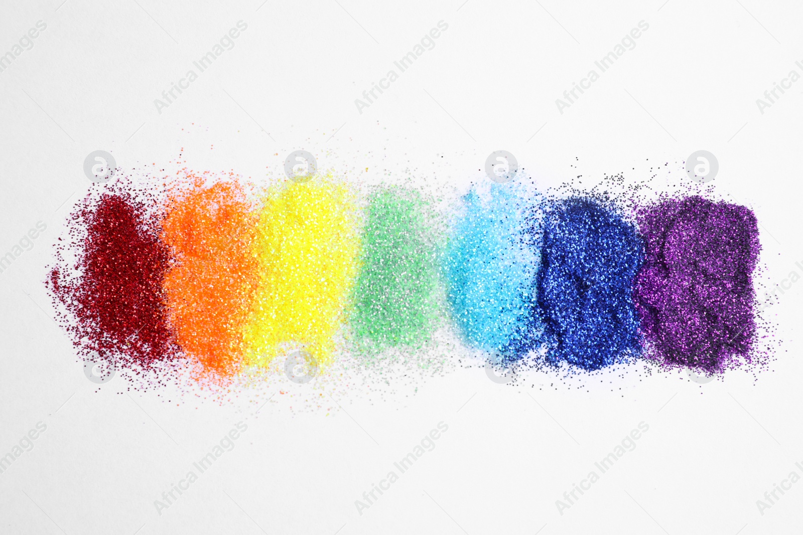 Photo of Bright glitters on white background, flat lay. Rainbow colors