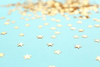Photo of Confetti stars on light blue background, closeup. Christmas celebration