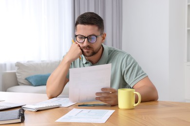 Photo of Man doing taxes at table in room