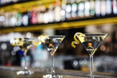 Photo of Glasses of lemon drop martini cocktail on bar counter. Space for text