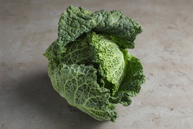 Fresh ripe savoy cabbage with water drops on grey table