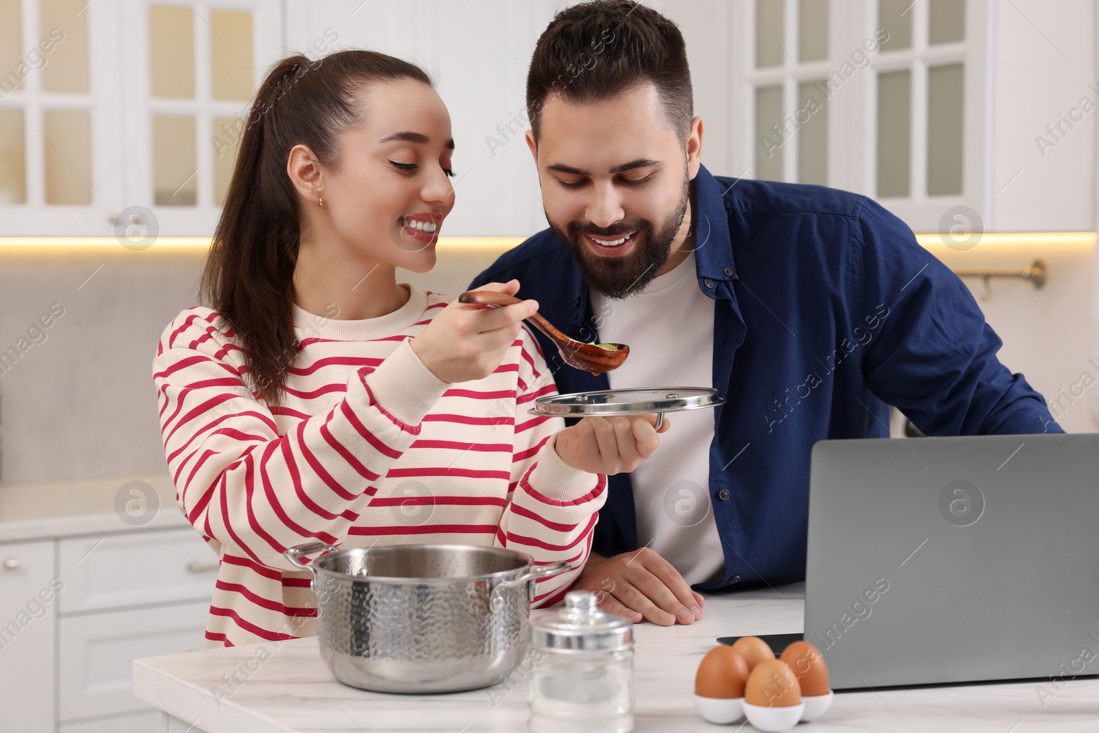 Photo of Happy lovely couple cooking together in kitchen