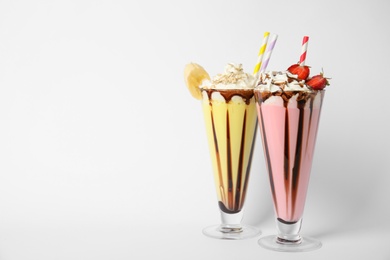 Photo of Glasses of tasty milk shakes on white background