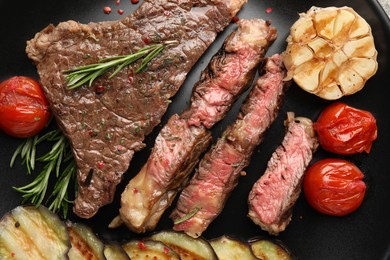 Photo of Delicious grilled beef steak with vegetables and spices on plate, top view
