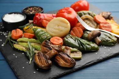 Photo of Delicious grilled vegetables on blue wooden table, closeup