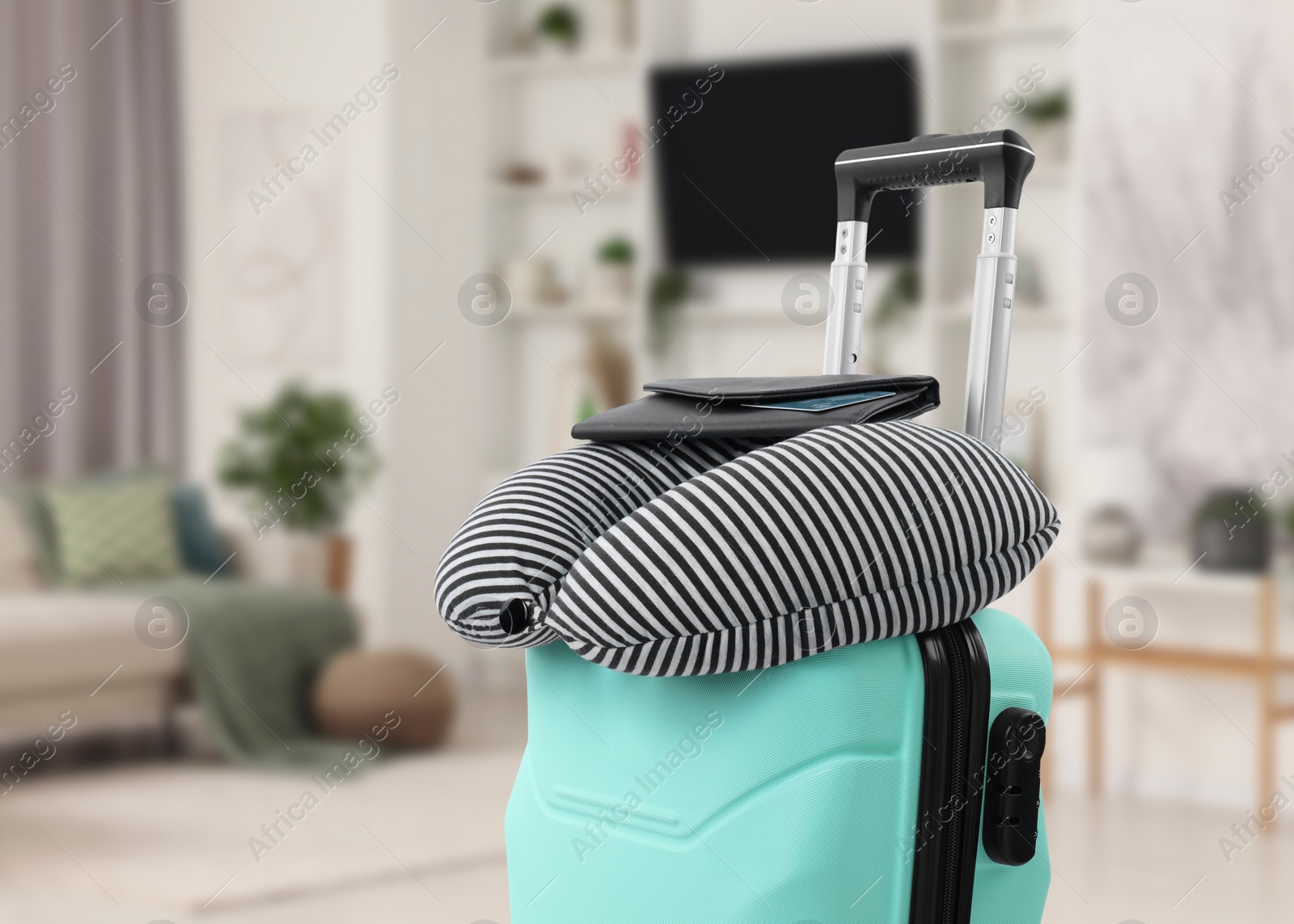 Image of Travel pillow and wallet on suitcase in room