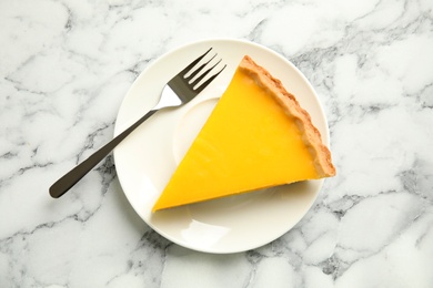 Photo of Slice of delicious homemade lemon pie on white marble table, top view