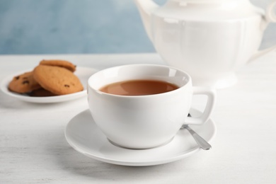 Photo of Cup of delicious tea with saucer on table