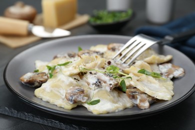 Photo of Delicious ravioli with tasty sauce and mushrooms served on table, closeup