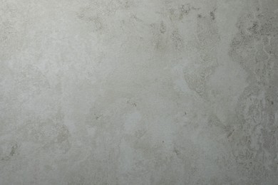 Photo of Texture of light grey stone surface as background, closeup