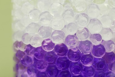 Photo of Different color fillers in glass vase, closeup. Water beads