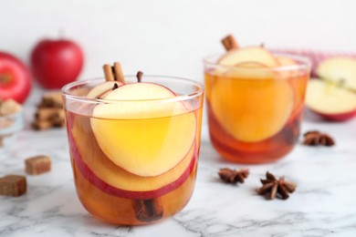 Photo of Aromatic hot mulled cider on white marble table