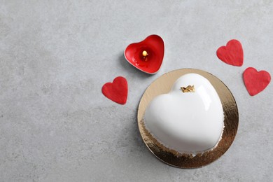 Photo of St. Valentine's Day. Delicious heart shaped cake, candle and confetti on light grey table, flat lay. Space for text