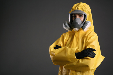 Photo of Woman wearing chemical protective suit on grey background, space for text. Virus research