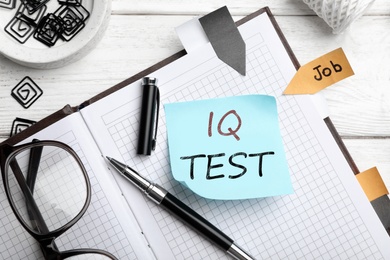 Image of Sticky note with text IQ Test and stationery on table, flat lay