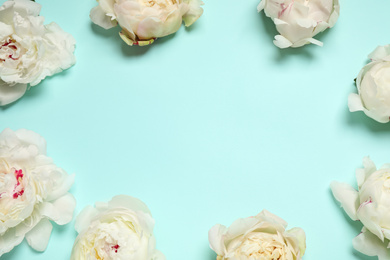 Photo of Beautiful white peonies on turquoise background, flat lay