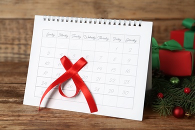 Photo of Calendar with marked Boxing Day date and gifts on wooden table