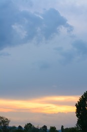 Photo of Picturesque view on cloudy sky over trees at sunset
