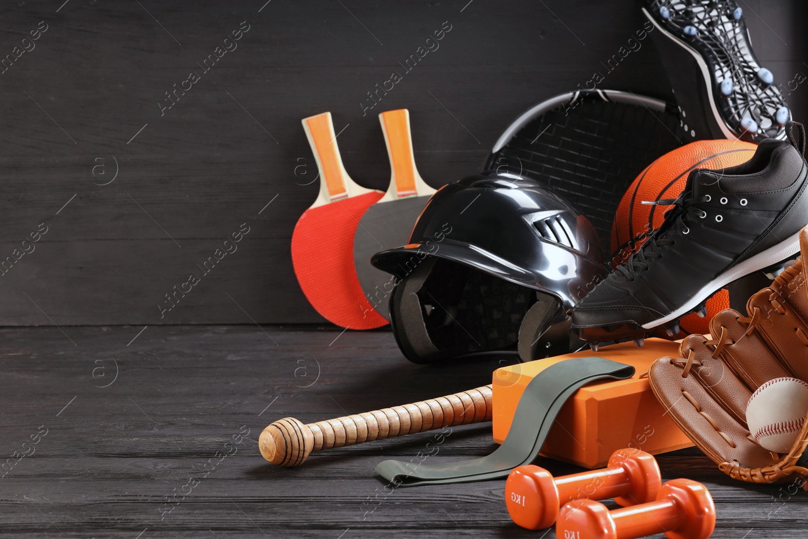 Photo of Many different sports equipment on dark grey wooden table, space for text