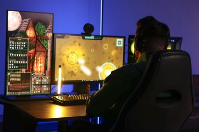 Photo of Man playing video games on computer at table indoors