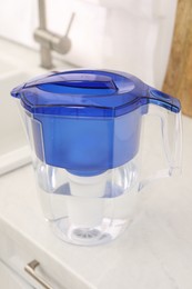 Photo of Water filter jug on white countertop in kitchen