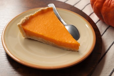 Photo of Plate with piece of fresh homemade pumpkin pie on table