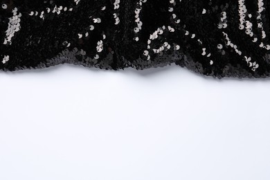 Photo of Black shiny sequin fabric on white background, top view. Space for text