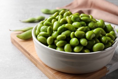 Photo of Bowl of delicious edamame beans on table, closeup