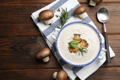 Photo of Delicious homemade mushroom soup served on wooden table, flat lay